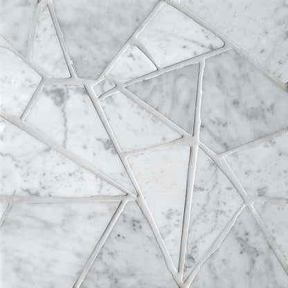 Close-up of a white Carrara marble stone mosaic with geometric patterns.